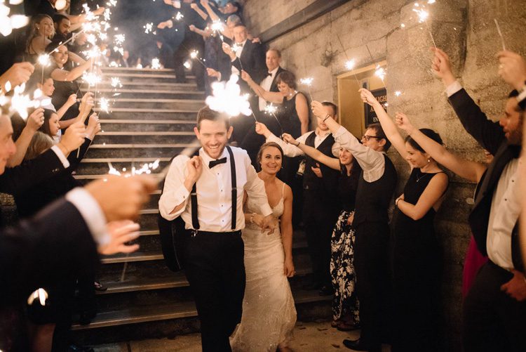 Bride and groom sparkler exit down the stairs at the Lightner Museum
