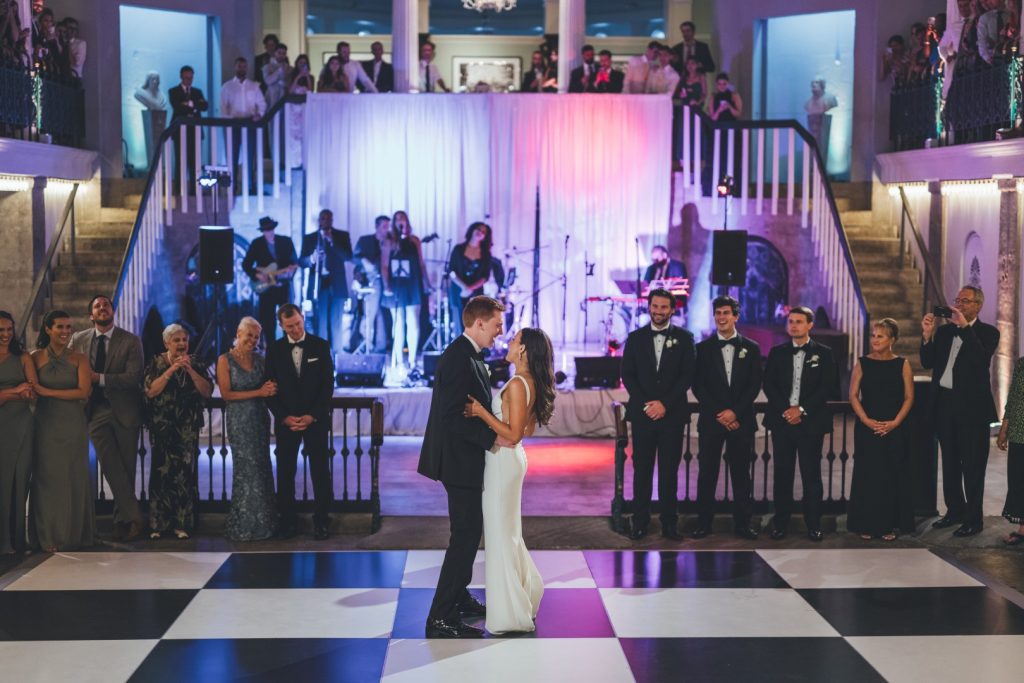 bride and groom dancing their first dance on checkerboard dance floor