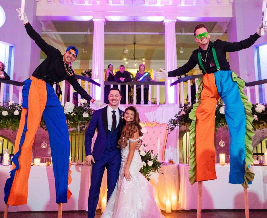 Stilt walkers pose with bride and groom