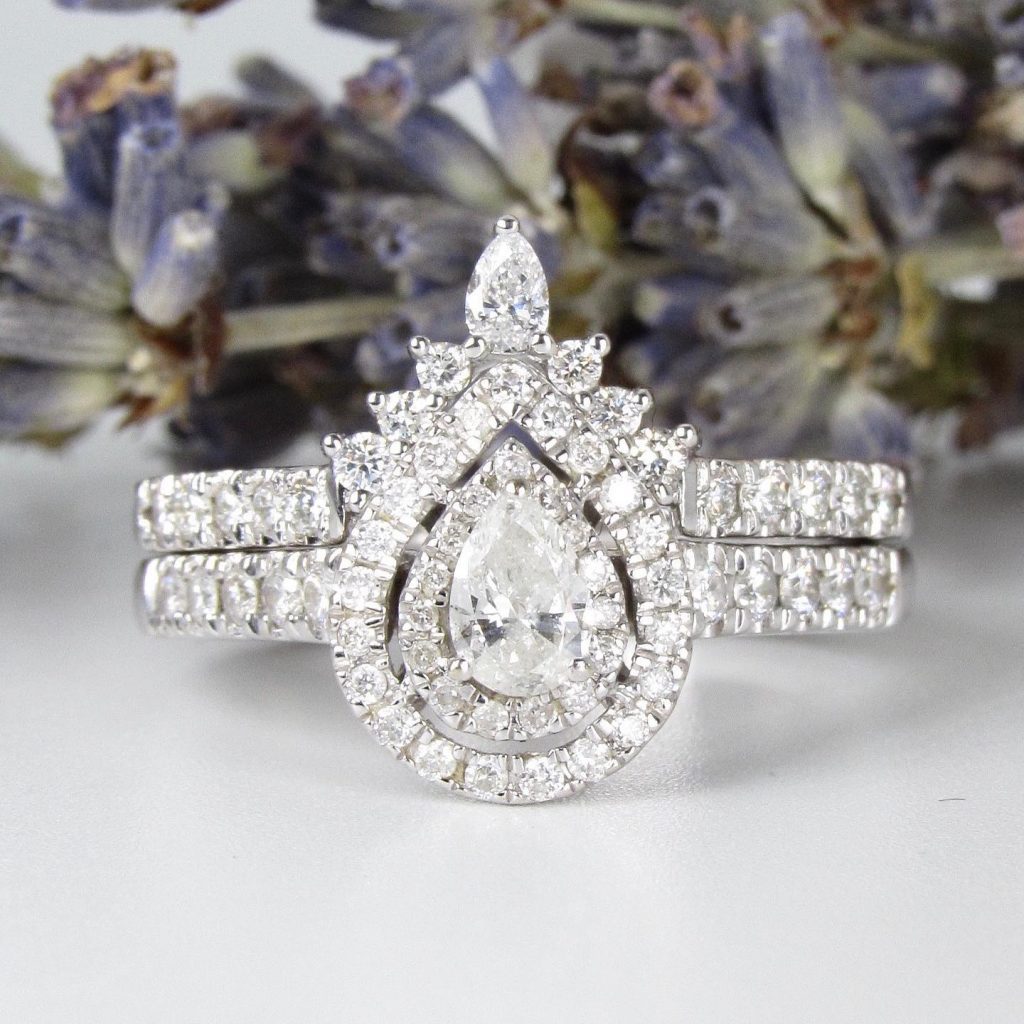 A pear-shaped diamond engagement ring with a diamond encrusted band.