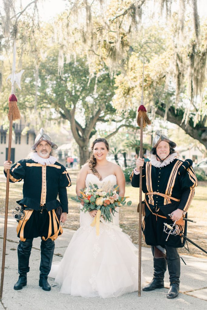 bride stands between two men dressed as Spanish Conquistadors