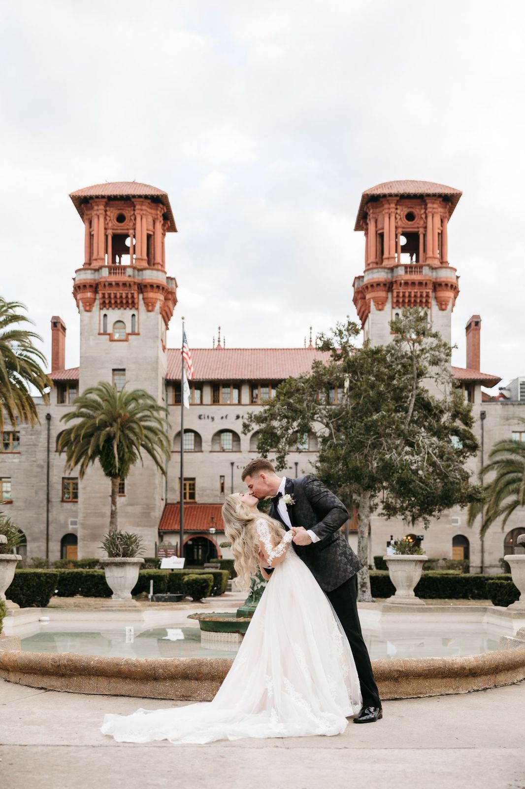 Bride and groom kissing near the fountain in front of the Lightner Museum in St. Augustine.
