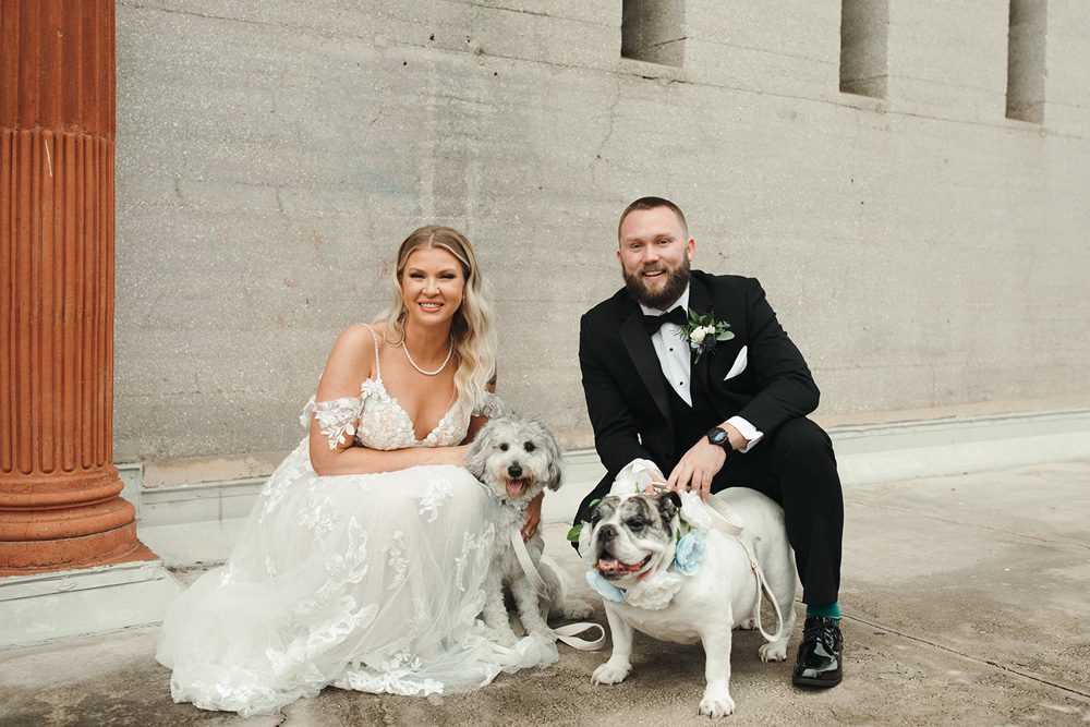 Bride and groom posing with their dogs