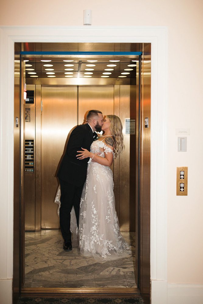 Bride and groom kiss in elevator