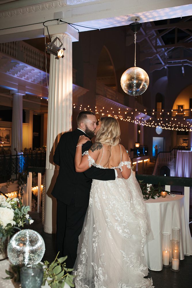 Bride and groom kissing under disco ball