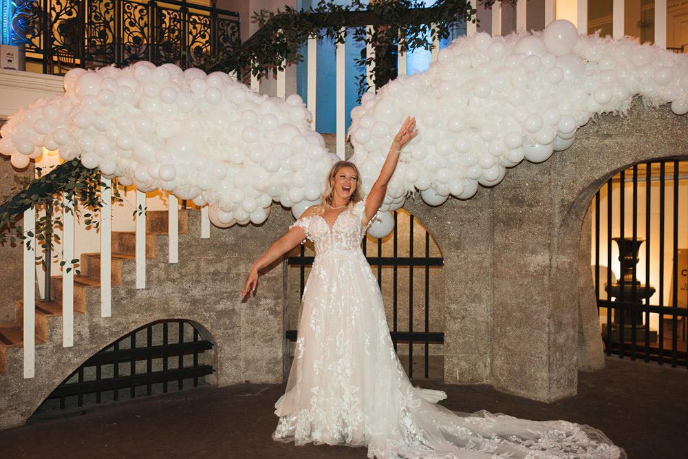 Bride standing under balloon angel wings display