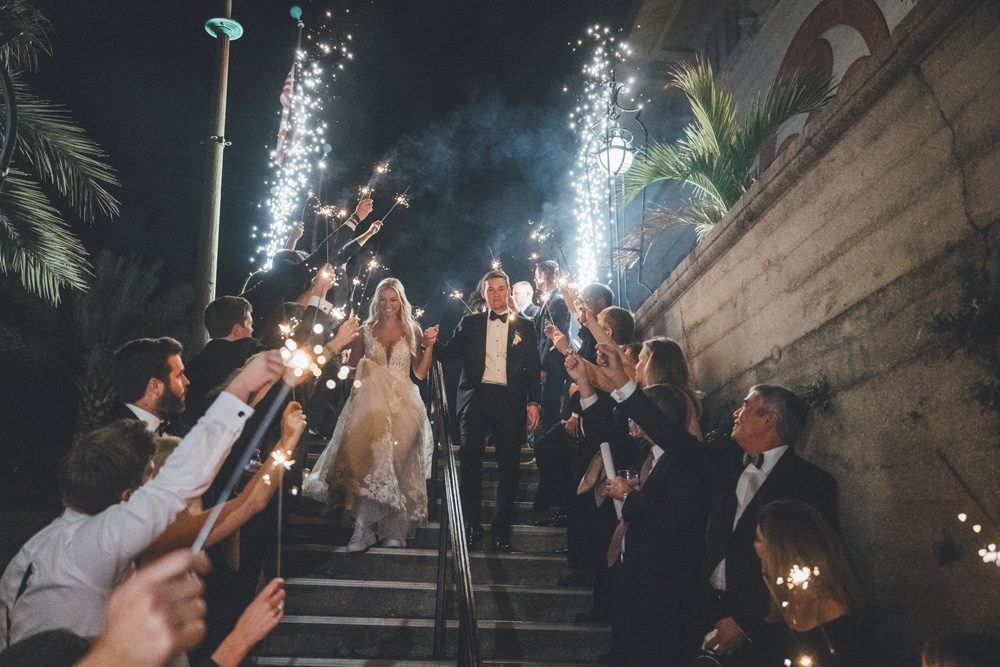 Bride and groom walking down the steps under sparkler exit