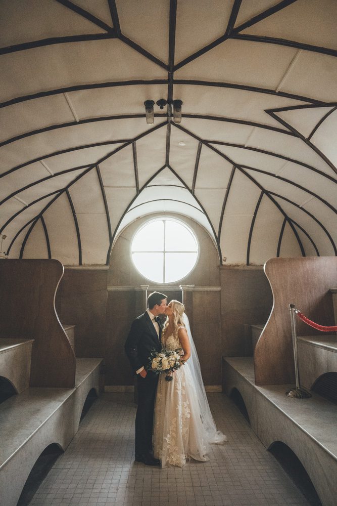 Bride and groom kissing in the chapel