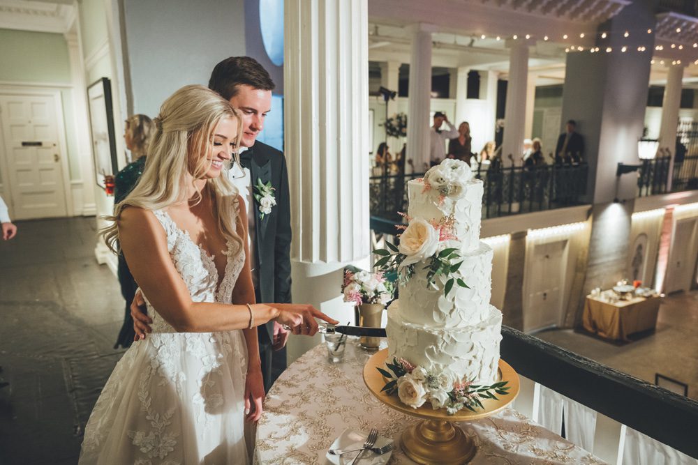 Bride and groom cutting cake.