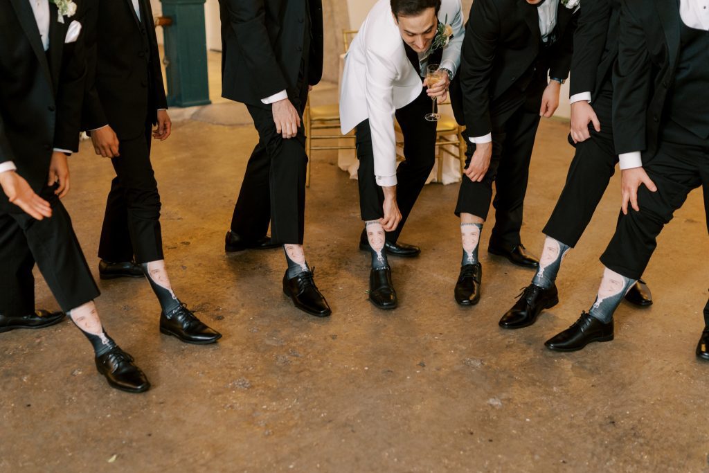 Groom David and wedding party showing off matching socks