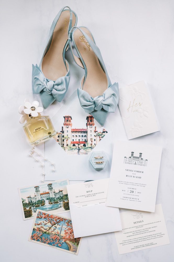 Bridal shoes, perfume bottle, wedding rings over pictures of the venue and invitation.
