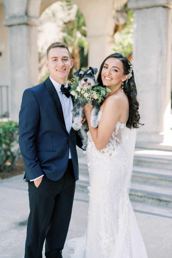 Bride and groom posing with their dog.