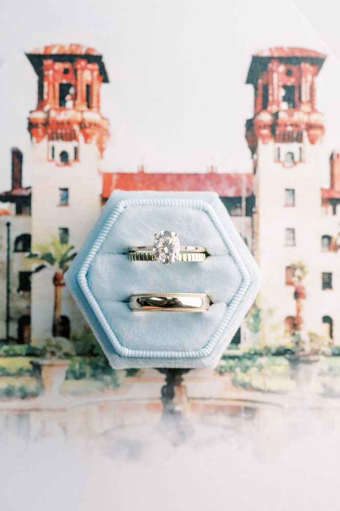 Wedding rings over a picture of the Lightner Museum