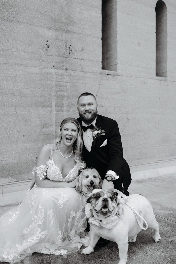 black and white photo of Cayla and Kevin with their two dogs
