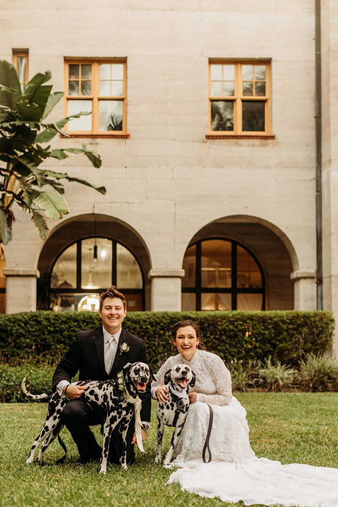 bride and groom posing with two Dalmatians