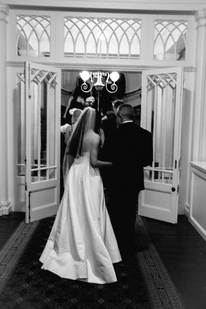 black and white photo of man walking daughter down the aisle