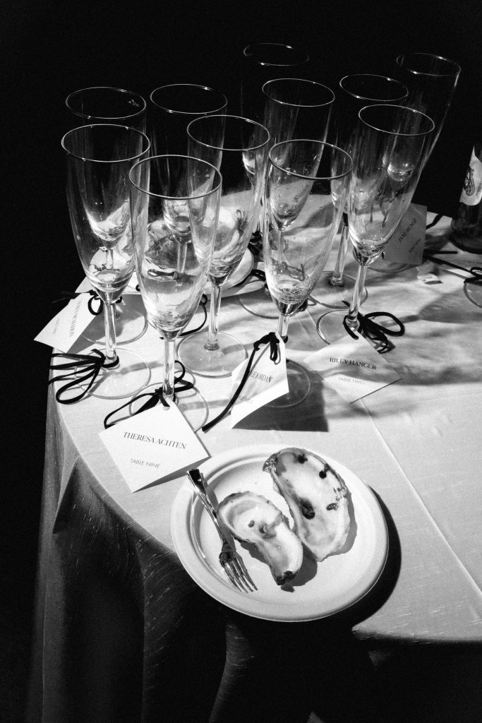 Black and white photo of empty champagne flutes and oyster