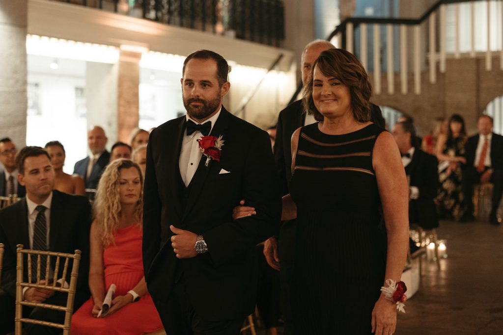 Groom Dane walking down the aisle with his parents