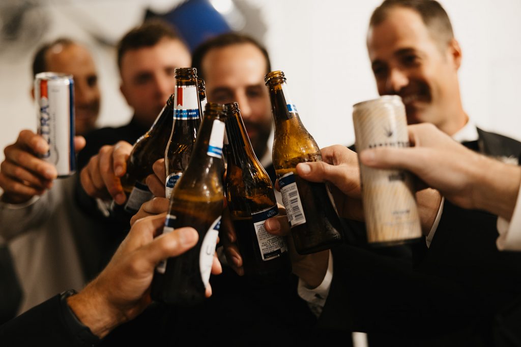 closeup of groom and groomsmen toasting each other