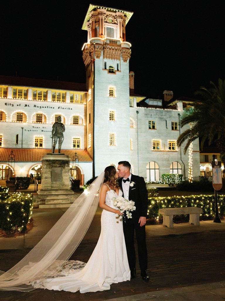bride and groom kiss outside The Lightner Museum during Nights of Lights