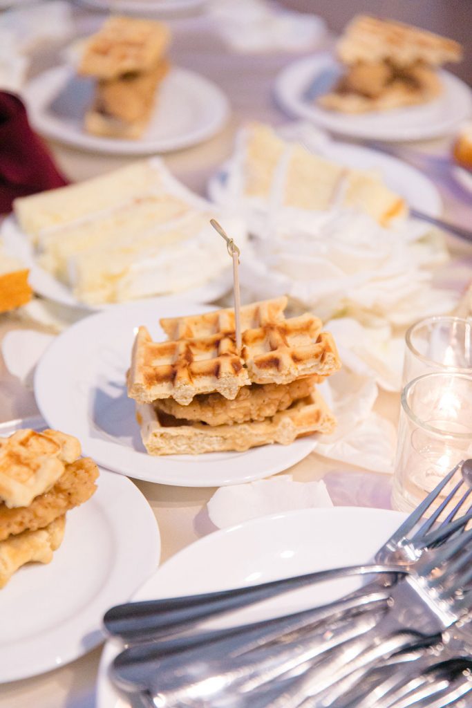 chicken and waffles next to plated wedding cake